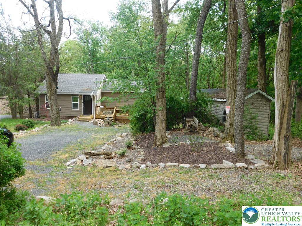 41 Reeder Street Mount Pocono, PA 18344 - Photo 3 of 41 Nestled among mature trees, a charming home with a gravel driveway and natural landscaping awaits.