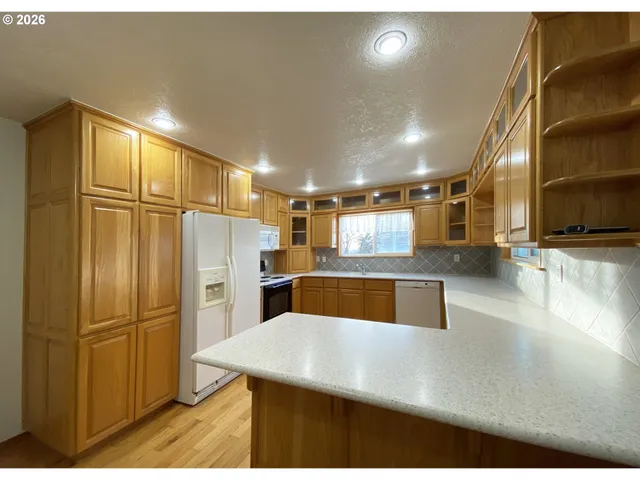 a kitchen with stainless steel appliances kitchen island granite countertop a refrigerator a stove and a sink