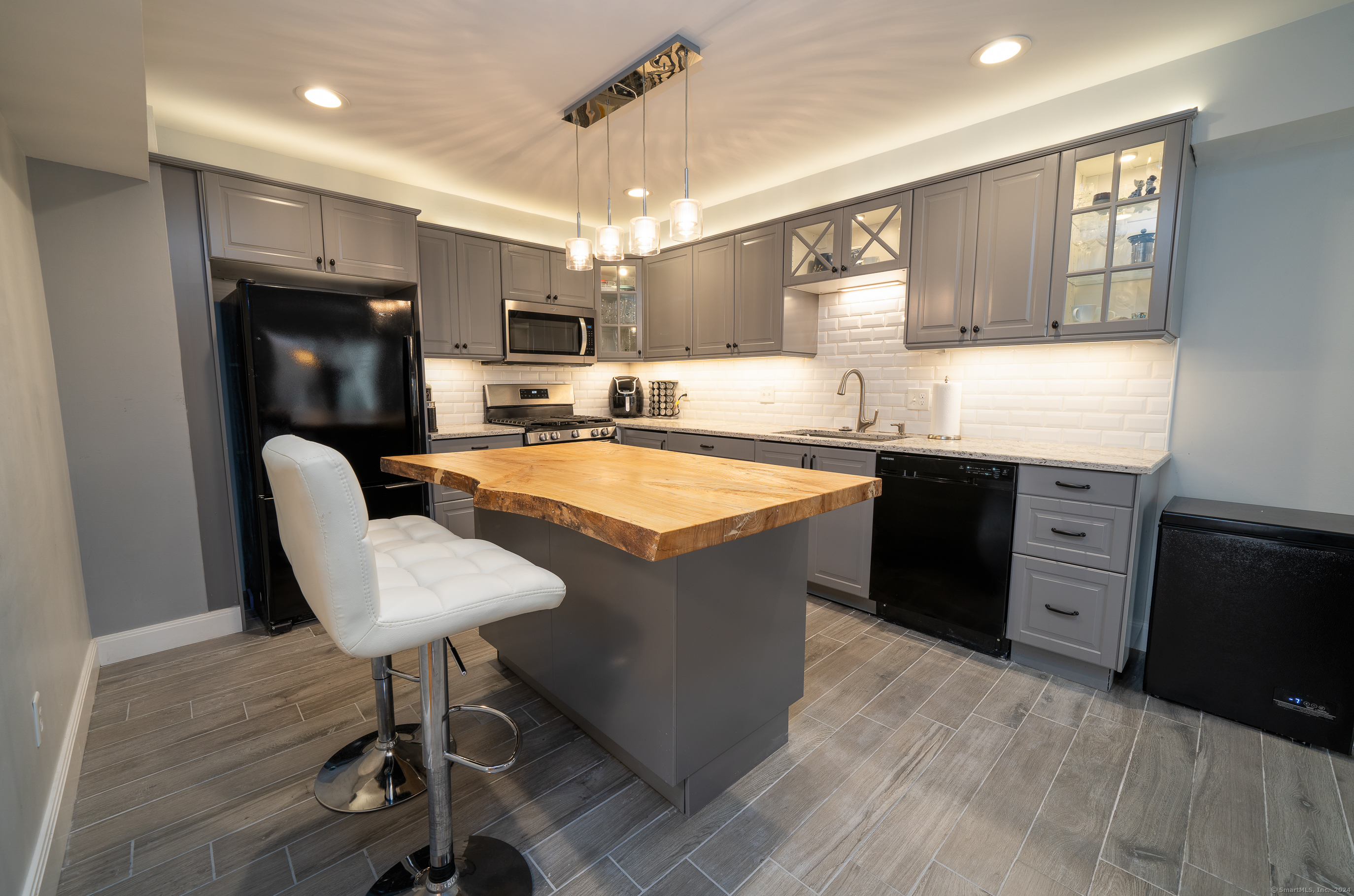 a kitchen with granite countertop a sink appliances and cabinets
