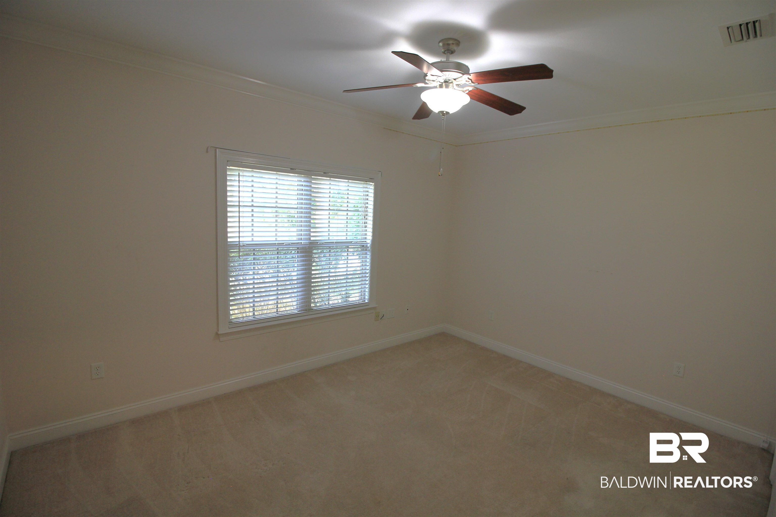 306 South Tee Drive Fairhope, AL 36532 - Photo 19 of 37 Unfurnished room with ceiling fan, light colored carpet, and ornamental molding