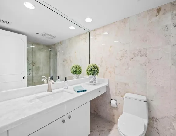 a bathroom with a toilet sink and mirror
