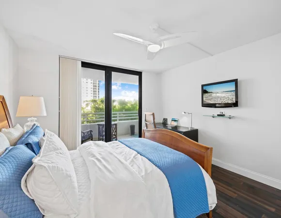 a bedroom with a bed and a flat tv screen on dresser