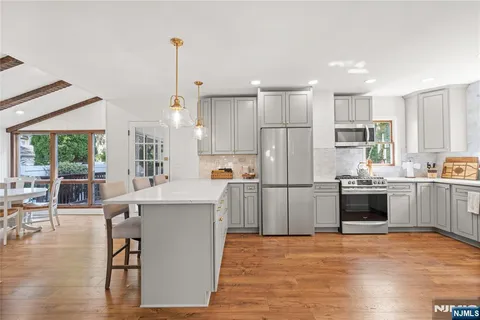 a kitchen with kitchen island a stove a refrigerator a counter top space and a center island