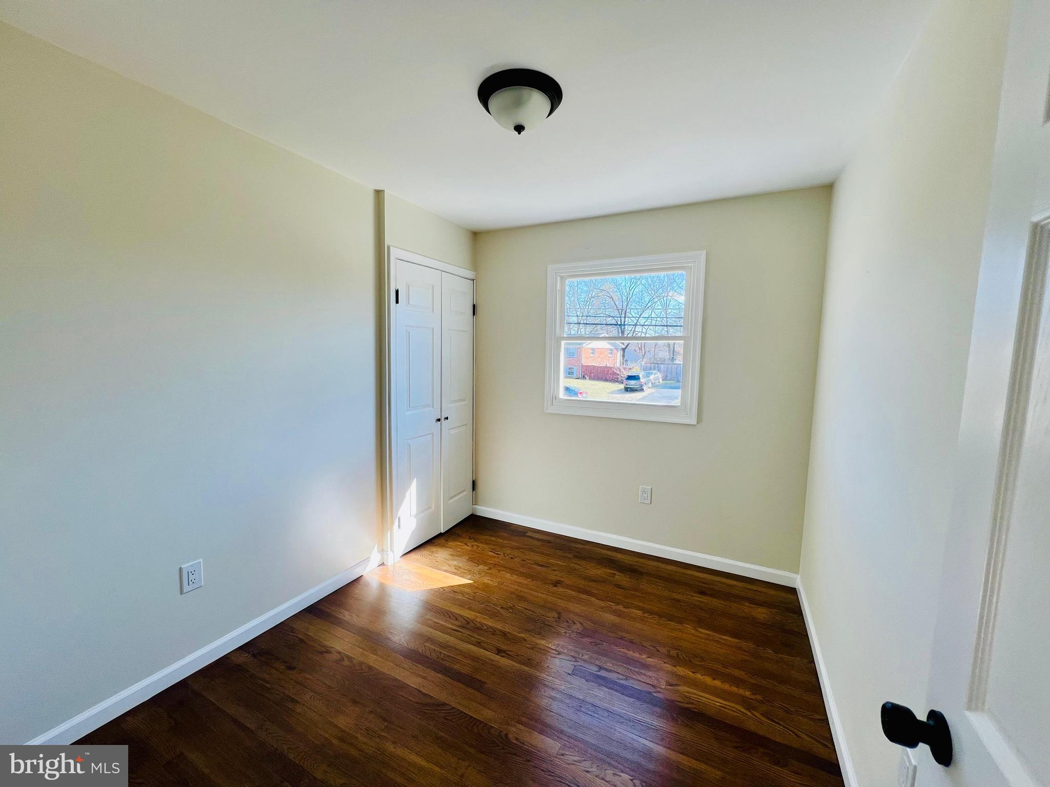 9826 Lomond Drive Manassas, VA 20109 - Photo 20 of 78 a view of an empty room with wooden floor and a window