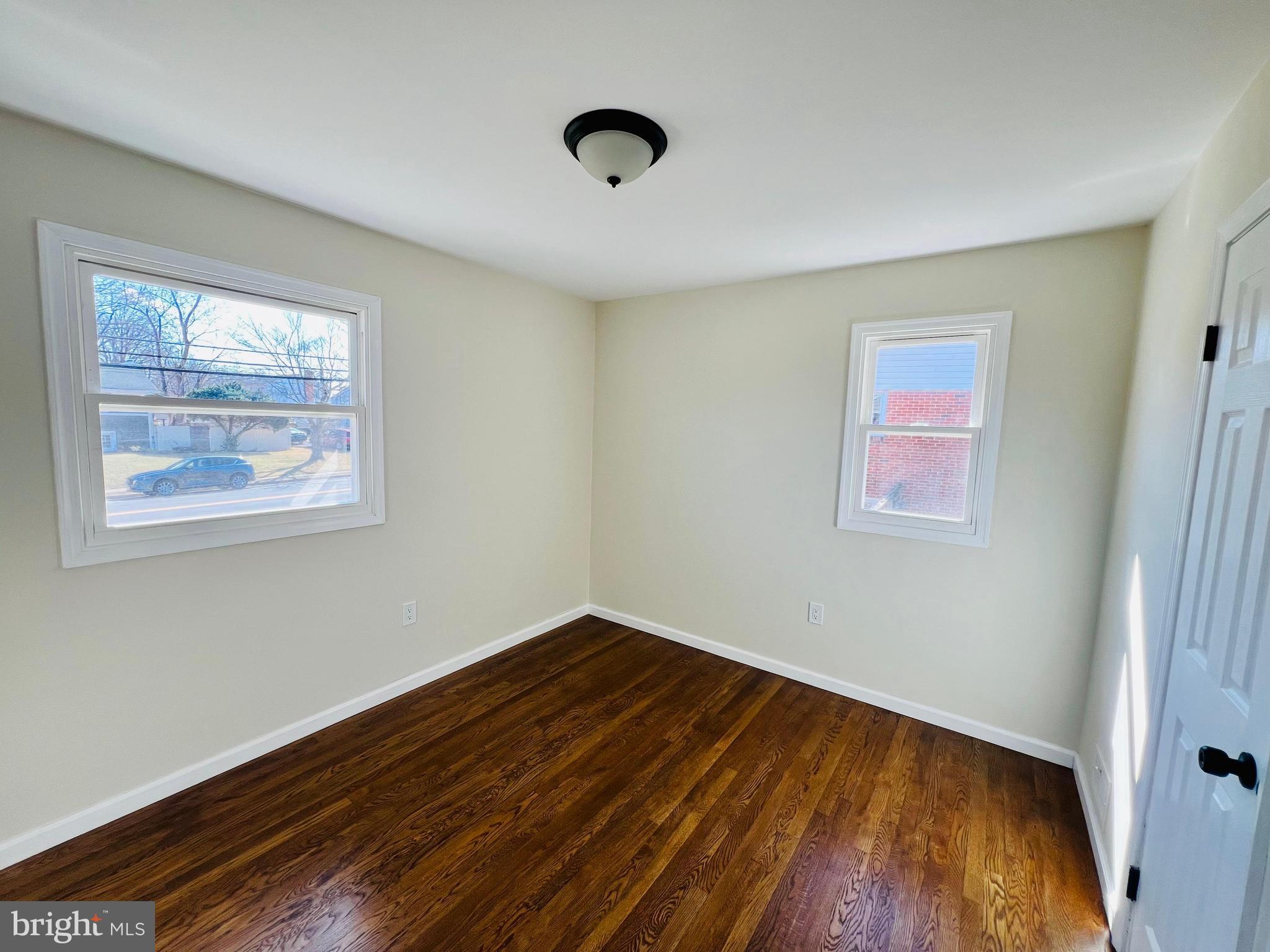 9826 Lomond Drive Manassas, VA 20109 - Photo 22 of 78 a view of an empty room with wooden floor and a window