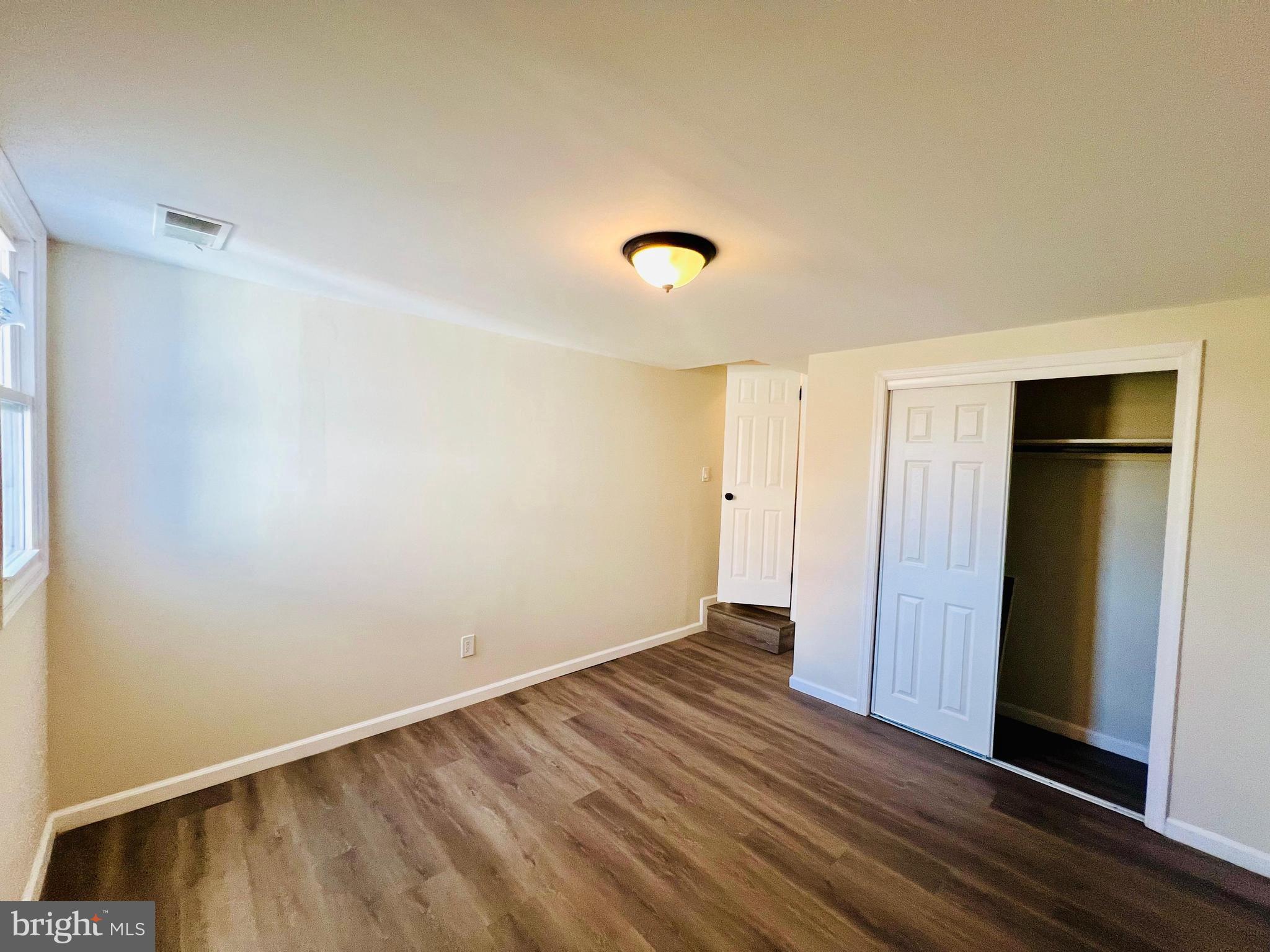 9826 Lomond Drive Manassas, VA 20109 - Photo 39 of 78 a view of an empty room with wooden floor and a window
