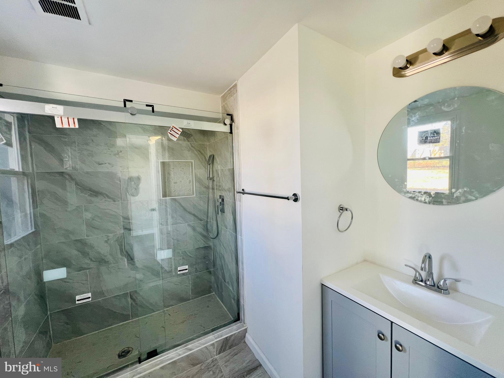 9826 Lomond Drive Manassas, VA 20109 - Photo 55 of 78 a bathroom with a shower a sink and mirror