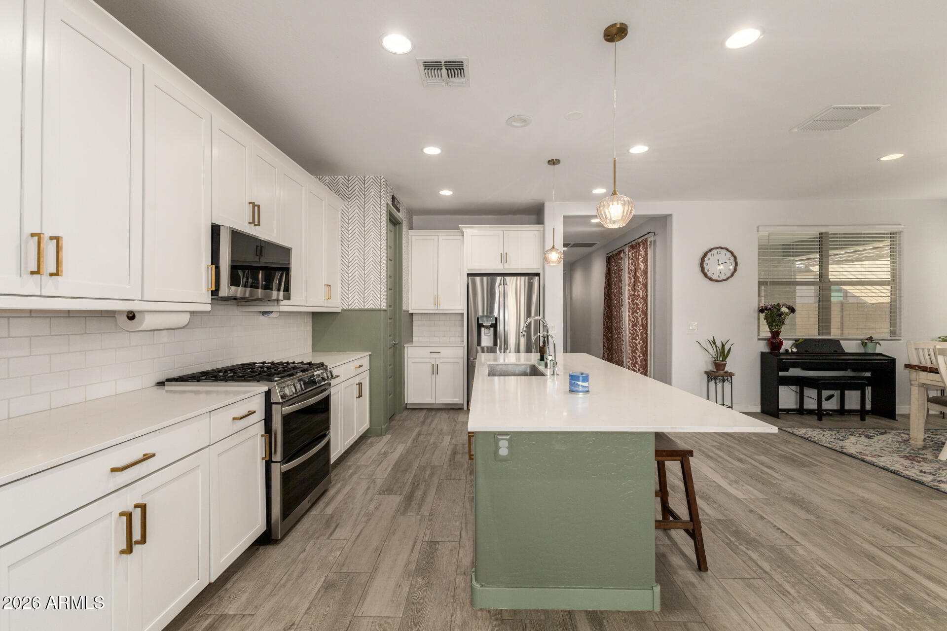 12560 East Ballentine Road Gold Canyon, AZ 85118 - Photo 12 of 35 a large kitchen with kitchen island a stove a sink a refrigerator and a dining table with wooden floor