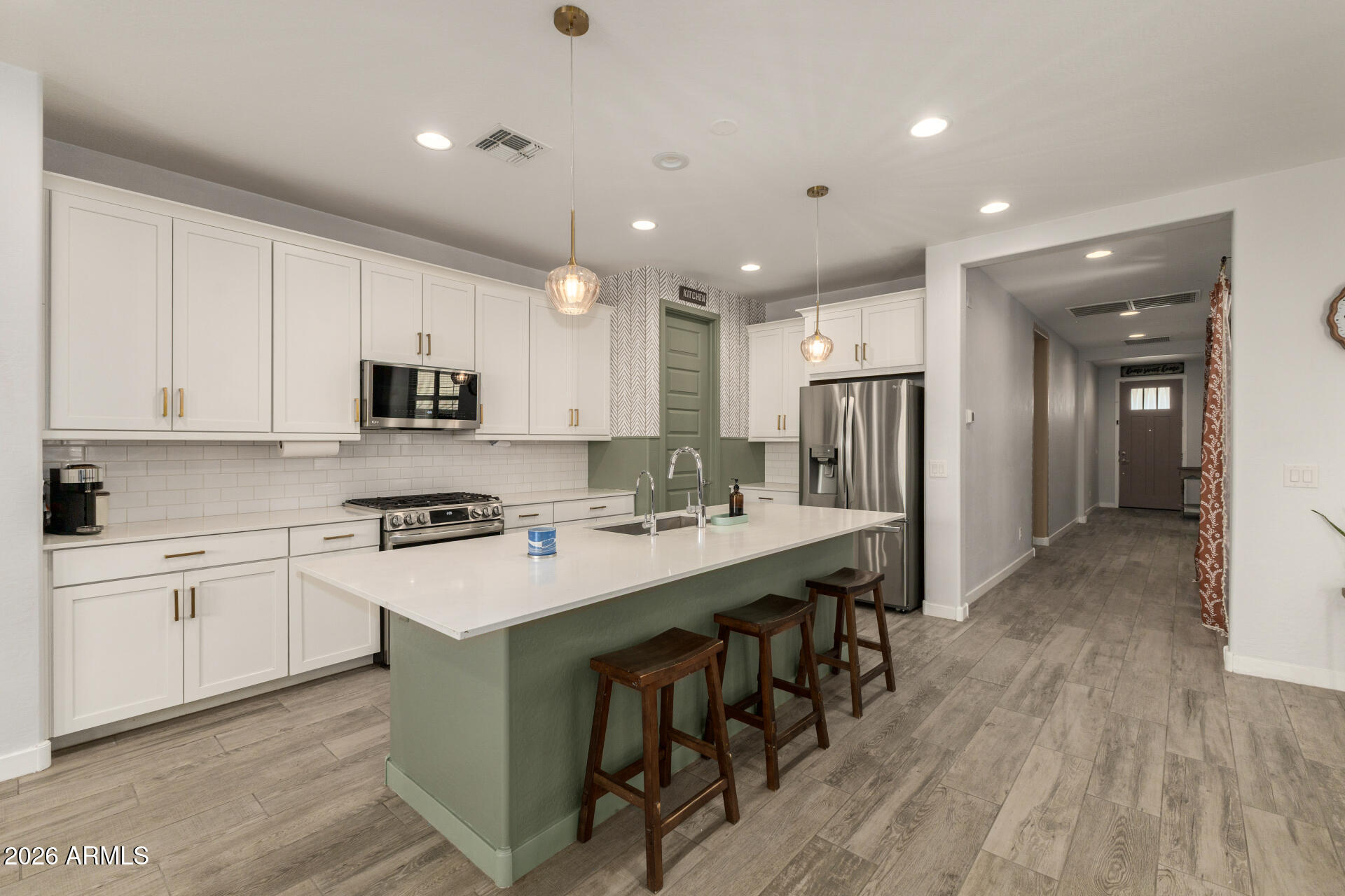 12560 East Ballentine Road Gold Canyon, AZ 85118 - Photo 13 of 35 a kitchen with stainless steel appliances kitchen island granite countertop a stove a sink a refrigerator and white cabinets with wooden floor