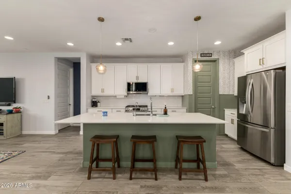 a kitchen with refrigerator and chairs