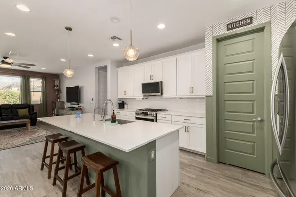 a kitchen with a sink stainless steel appliances and white cabinets
