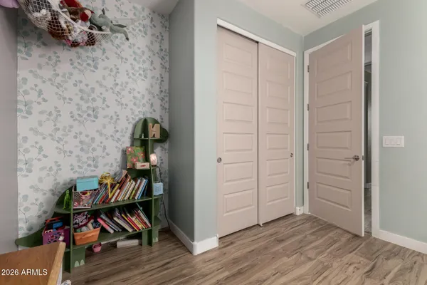 an empty room with wooden floor and book shelf