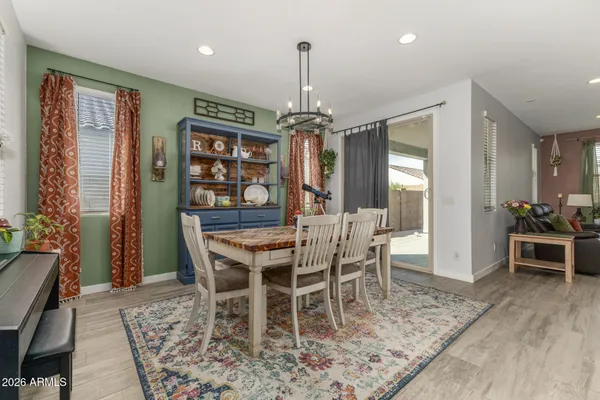 a dining room with furniture a chandelier and wooden floor