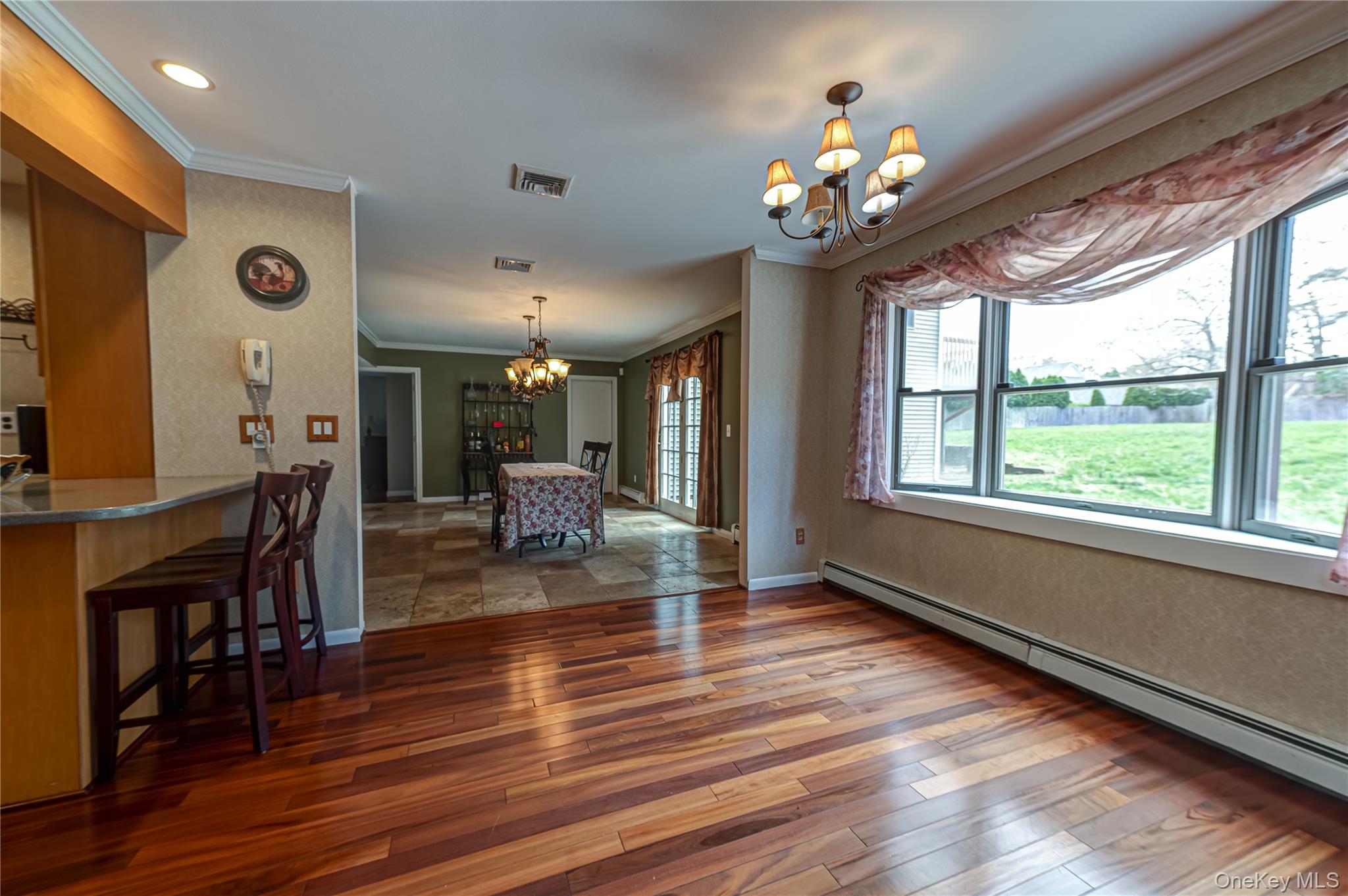 114 Randall Road Ridge, NY 11961 - Photo 15 of 48 a dining room with wooden floor a chandelier a wooden table and chairs