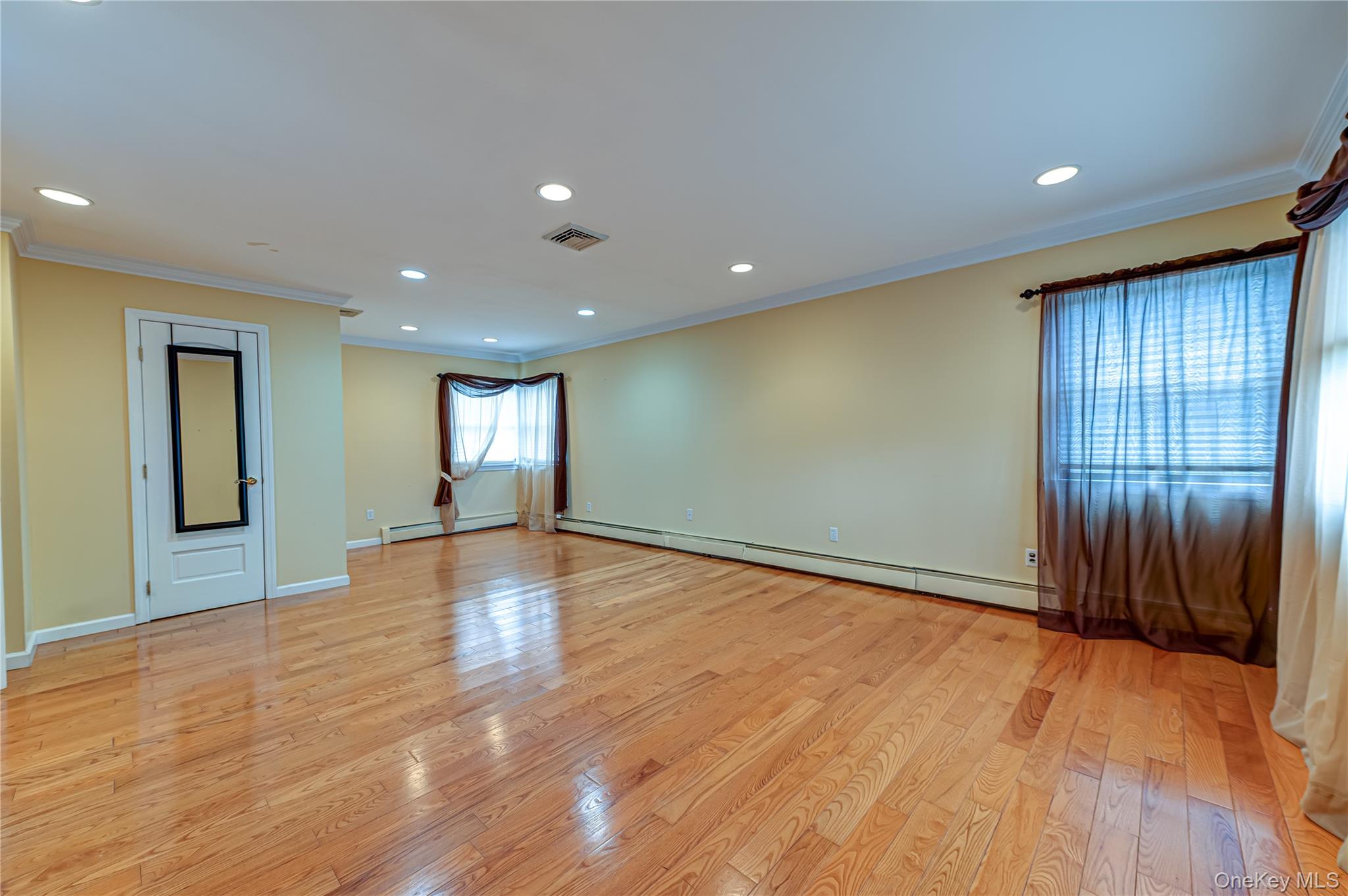 114 Randall Road Ridge, NY 11961 - Photo 28 of 48 an empty room with wooden floor and windows