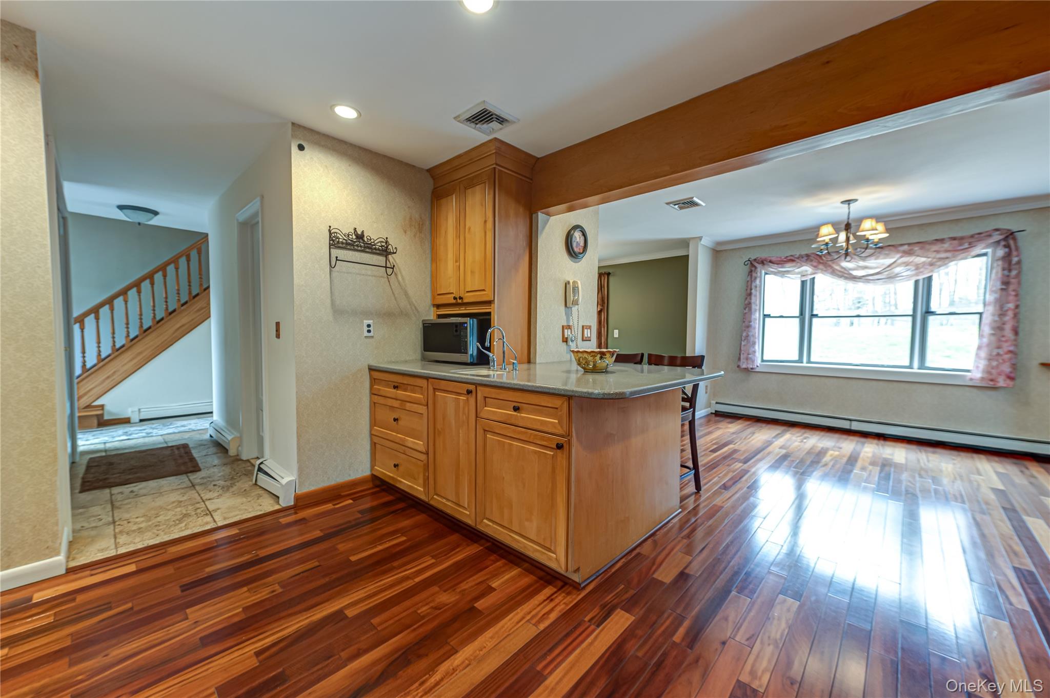 114 Randall Road Ridge, NY 11961 - Photo 9 of 48 a kitchen with stainless steel appliances granite countertop a refrigerator a sink dishwasher a stove and white countertops with wooden floor