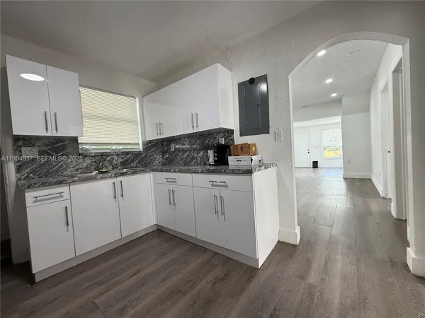 a kitchen with a sink window and cabinets