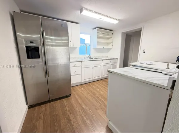 a kitchen with a refrigerator sink and cabinets