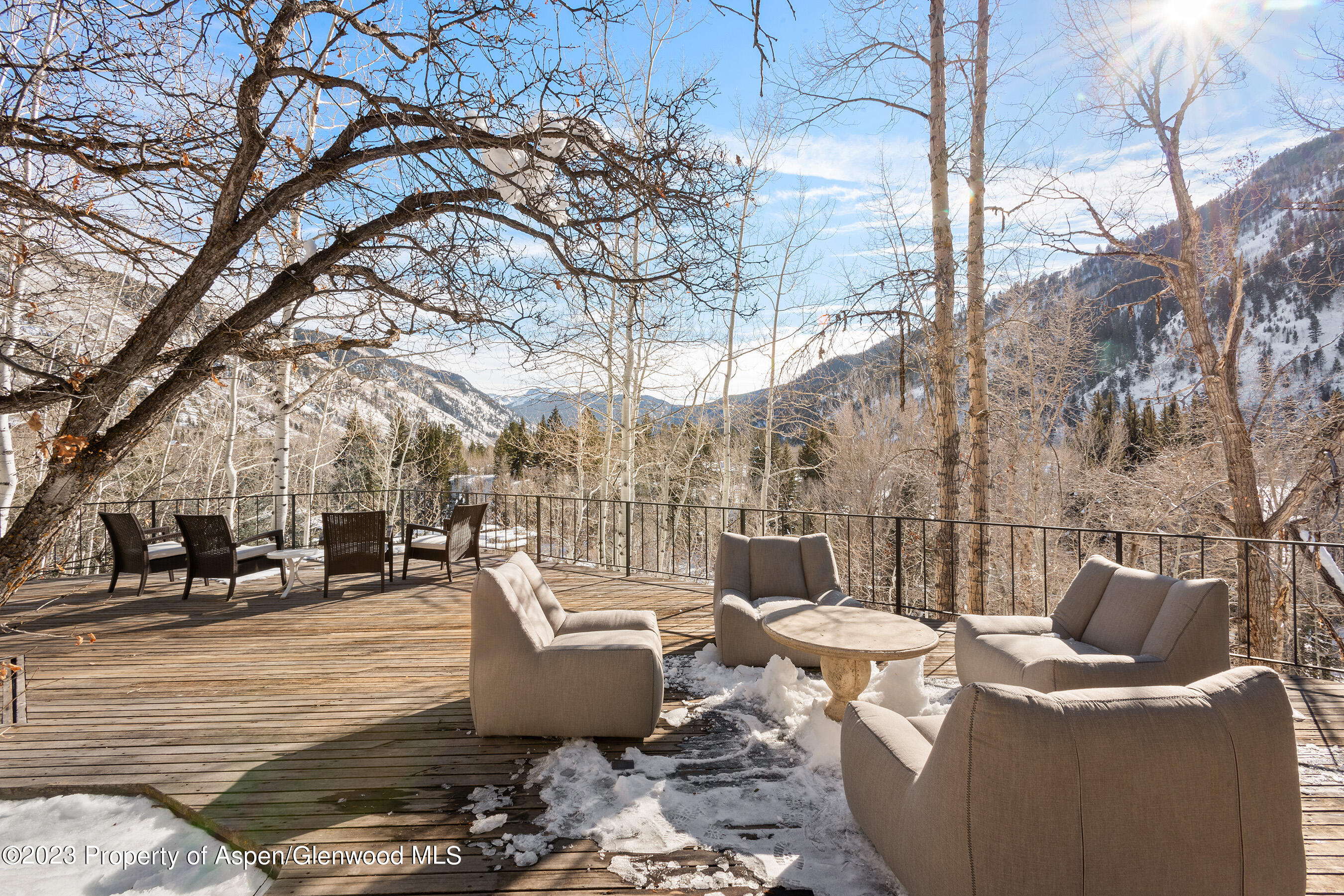 164 Eastwood Road Aspen, CO 81611 - Photo 38 of 42 a view of a patio with couches table and chairs under an umbrella