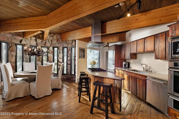 a kitchen with a table chairs and wooden floor