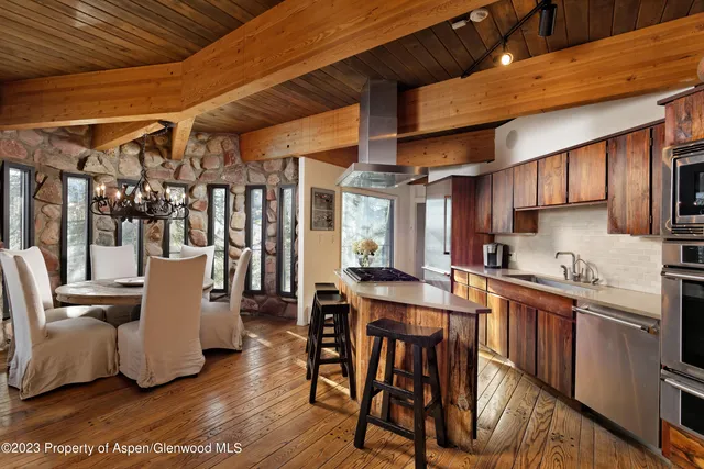 a kitchen with a table chairs and wooden floor