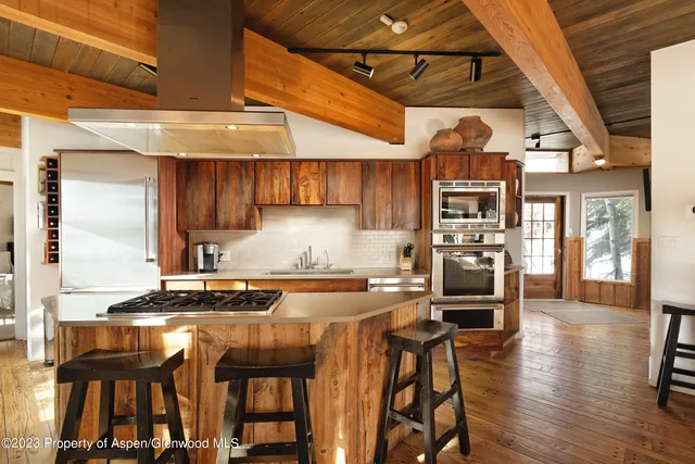 a kitchen with granite countertop wooden floors and wooden cabinets