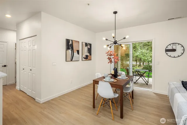 a dining room with furniture a chandelier and wooden floor