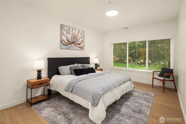 a bedroom with a bed and a large window