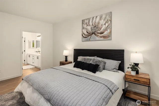 a bedroom with a bed and painting on the wall