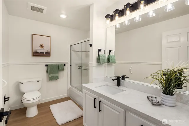 a bathroom with a sink a toilet and shower