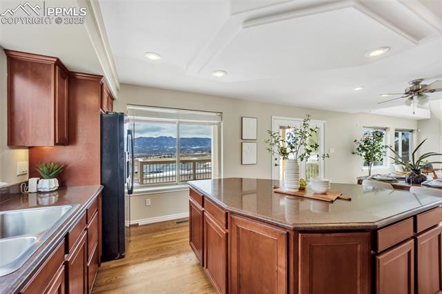 13884 Windy Oaks Road Colorado Springs, CO 80921 - Photo 6 of 21 Kitchen featuring light wood-style flooring, recessed lighting, a sink, a mountain view, and black fridge