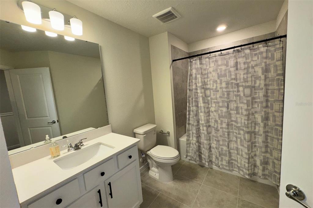 2759 Fetching Trail Davenport, FL 33896 - Photo 14 of 14 a bathroom with a double vanity sink toilet and shower