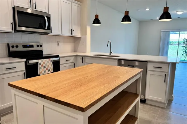 a kitchen with stainless steel appliances a sink a stove and microwave