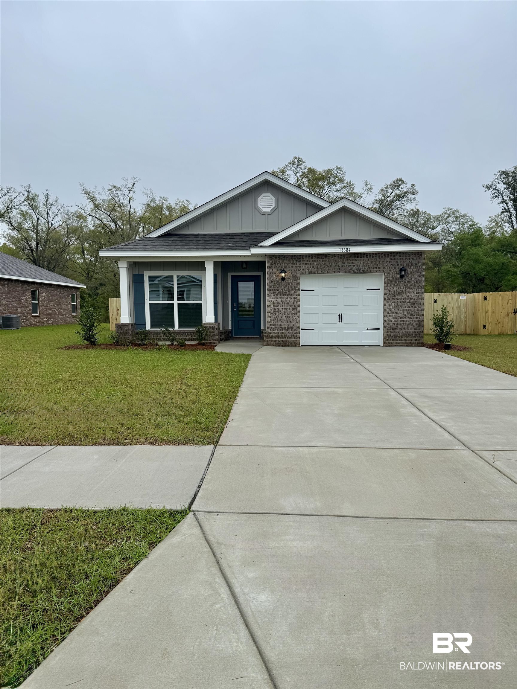13684 Shea Circle Foley, AL 36535 - Photo 1 of 35 View of front of house with fence, an attached garage, concrete driveway, a front yard, and brick siding