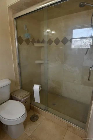 a bathroom with a toilet and a shower