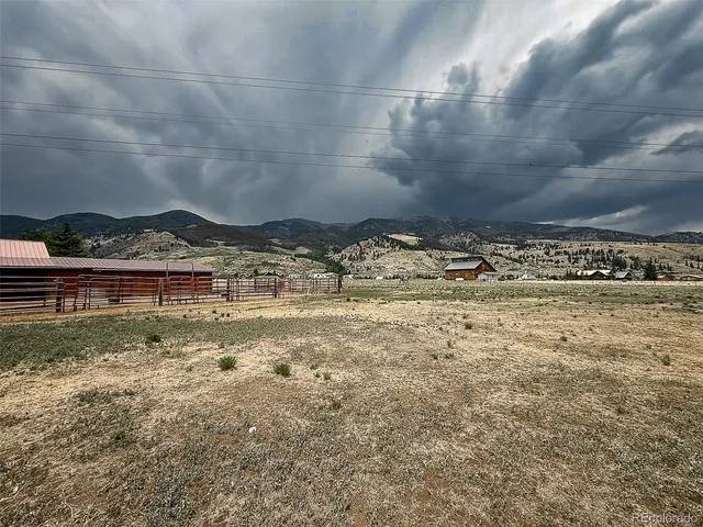 a view of a dry yard with wooden fence