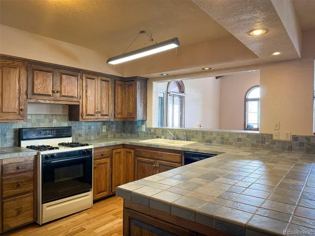 a kitchen with a stove sink and cabinets