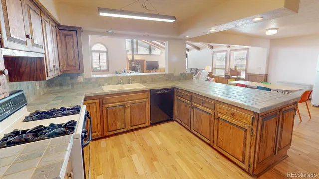 a kitchen with stainless steel appliances granite countertop a sink stove and cabinets