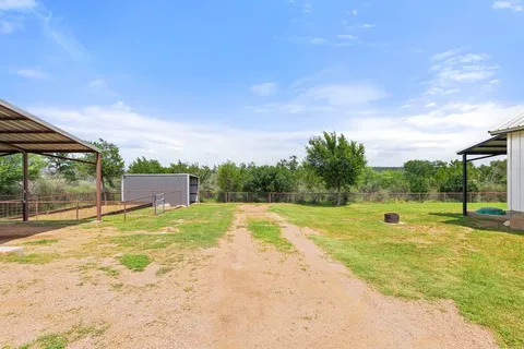a view of large house with a big yard and large tree