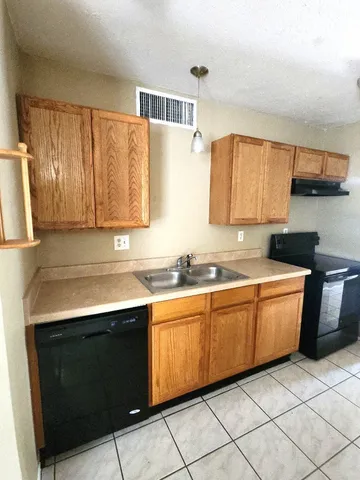 a kitchen with granite countertop a sink stove and cabinets