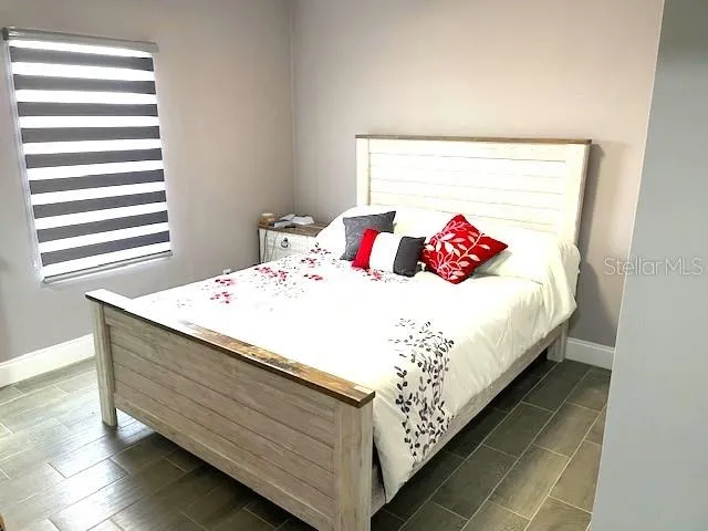 a bed sitting in a bedroom and wooden floor
