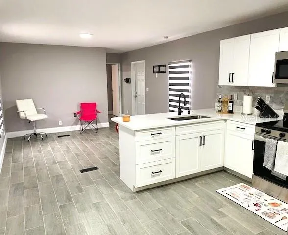 a room with a chair and white cabinets