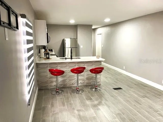 a kitchen with stainless steel appliances granite countertop a sink refrigerator and cabinets