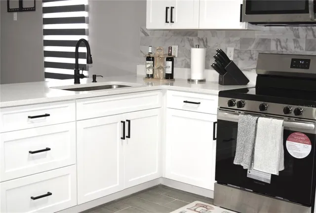 a kitchen with stainless steel appliances kitchen island granite countertop a sink stove refrigerator and cabinets