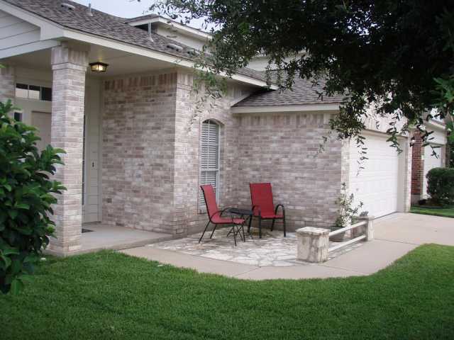a view of a chair and table in backyard of the house