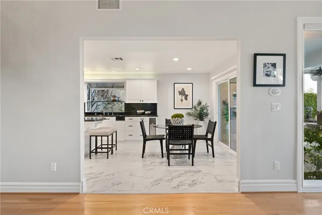 a kitchen with granite countertop white cabinets and stainless steel appliances