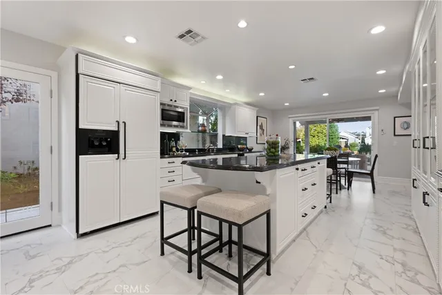 a kitchen with stainless steel appliances kitchen island granite countertop a sink and cabinets