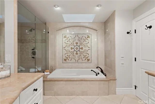 a bathroom with a granite countertop tub sink and mirror