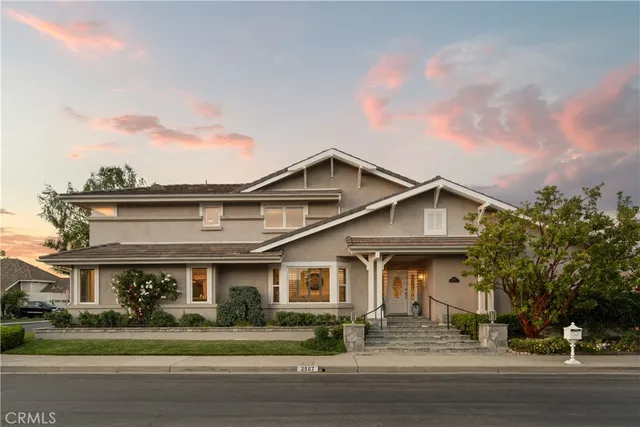 a view of a house with a yard and potted plants