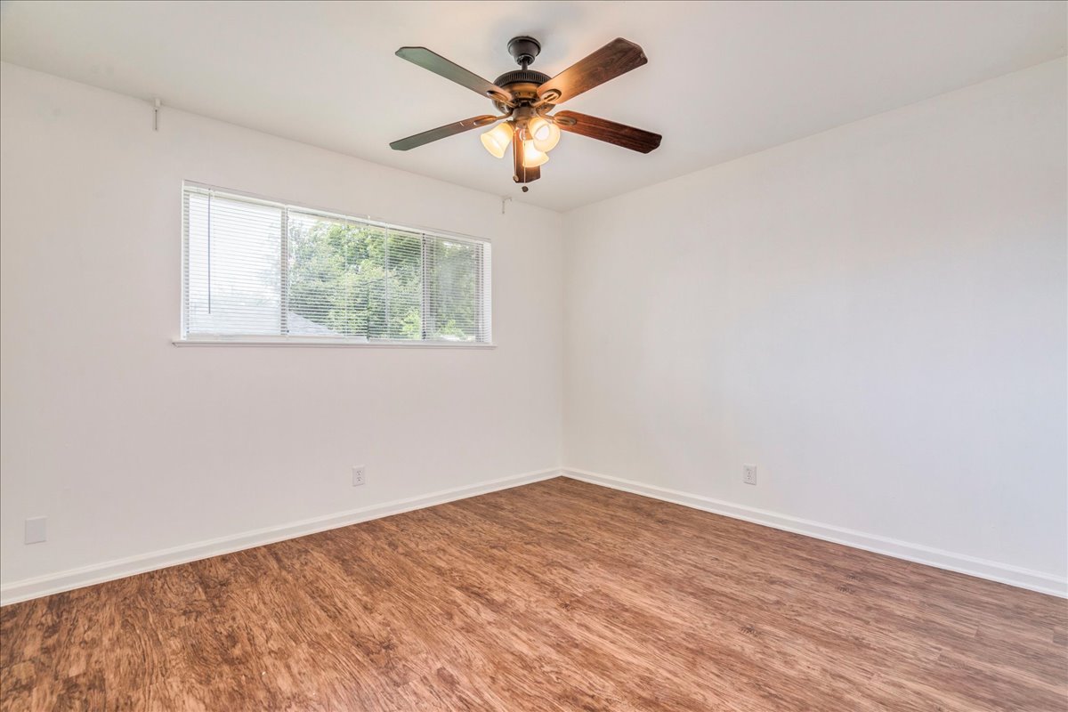 1417 Braes Ridge Drive, Unit B Austin, TX 78723 - Photo 18 of 22 an empty room with wooden floor and ceiling fan
